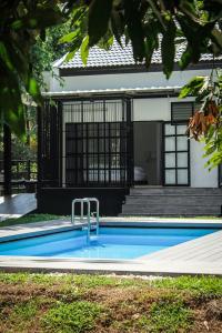a swimming pool in front of a house at Ban Rub Lom Pool Villa in Rayong