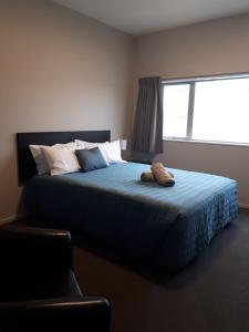 1 dormitorio con cama con almohada y ventana en Northpark Motel, en Timaru