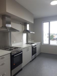 a kitchen with white appliances and a large window at Northpark Motel in Timaru