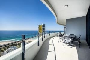 a balcony with a table and chairs and the ocean at The Wave Resort in Gold Coast