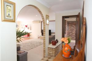 un arco en una sala de estar con un jarrón naranja en Two 46 Brodie, en Coffs Harbour
