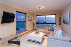 a living room with a couch and a tv at Breathtaking views in Blouberg! in Bloubergstrand