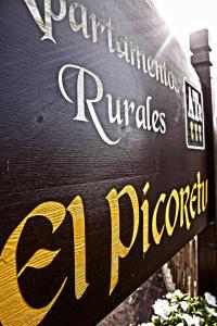 a sign for a restaurant with the name of the street at Apartamentos Rurales El Picoretu in Mestas de Con