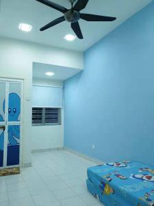 Jest to niebieski pokój z wentylatorem sufitowym i łóżkiem. w obiekcie New Luxury JB Homestay w mieście Kulai
