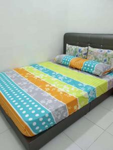 łóżko z kolorową pościelą i poduszkami w obiekcie New Luxury JB Homestay w mieście Kulai