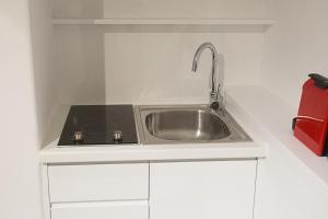 - une cuisine blanche avec un évier dans l'établissement Dimokritou 4 Apartment, à Athènes