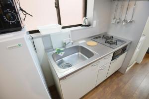 a small kitchen with a sink and a refrigerator at Roppongi Japan House602 in Tokyo