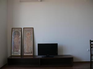 a room with a tv and two posters on a wall at Complex Kentavar - Free Fast WiFi in Sveti Vlas +18 photos