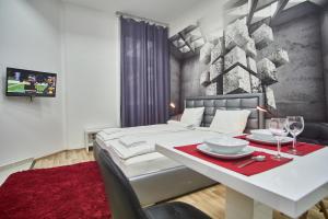 a bedroom with a white bed and a table with wine glasses at K51 Apartman | Budapest in Budapest