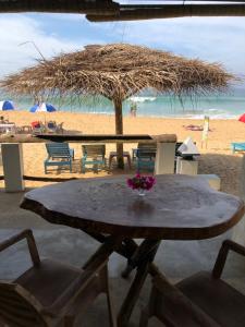 a table with a vase of flowers on a beach at Blue Ocean Villa in Hikkaduwa