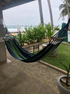 a hammock in front of a beach with the ocean at Blue Ocean Villa in Hikkaduwa