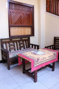 una mesa y dos bancos en una habitación en Arjuna Homestay Ubud, en Ubud