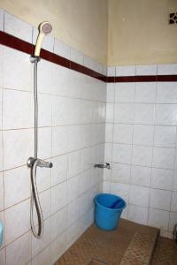 a shower in a bathroom with a blue bucket at Arjuna Homestay Ubud in Ubud