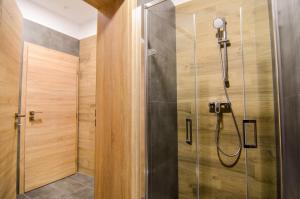 eine Dusche im Bad mit Holzwänden in der Unterkunft Apartmány Málek in Valtice