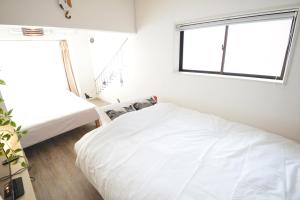 two beds in a room with a window at Roppongi Cat House601 in Tokyo