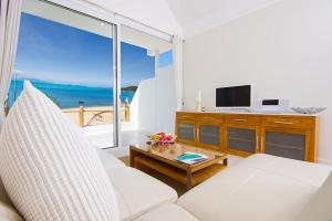 a living room with a white couch and a large window at B1 Beachfront Apartments in Bophut 
