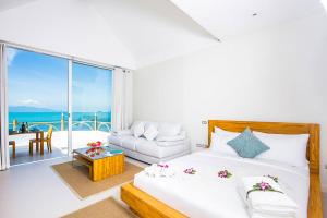ein Schlafzimmer mit einem Bett und ein Wohnzimmer mit Aussicht in der Unterkunft B1 Beachfront Apartments in Bophut 