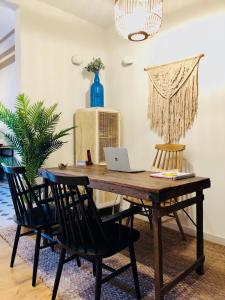 a wooden table with chairs and a laptop on it at Casa Vaganto in Barcelona