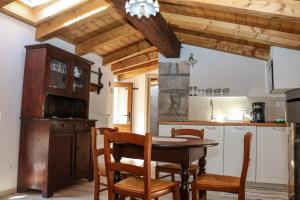 a kitchen with a wooden table and chairs at Casa del Castagno in Pulfero
