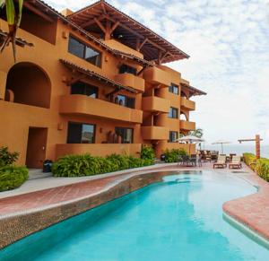 un complejo con piscina frente a un edificio en Hotel la Quinta de Don Andres en Zihuatanejo