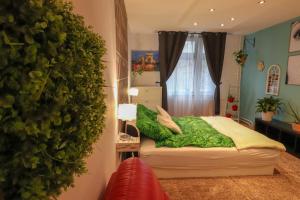 a bedroom with a green wall next to a bed at Amina's Apartment in Budapest