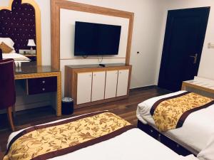 a hotel room with two beds and a television at Luxury hotel apartments in Tabuk
