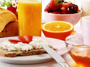 ein Teller mit Toast, Obst und Orangensaft in der Unterkunft Hotel Seewisch in Flessenow + 17 Fotos