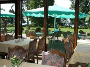 ein Restaurant mit Tischen und Stühlen und einem großen Fenster in der Unterkunft Hotel Seewisch in Flessenow