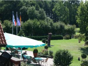 Eine Person sitzt unter einem Sonnenschirm in einem mit Flaggen geschmückten Garten. in der Unterkunft Hotel Seewisch in Flessenow