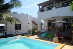 a villa with a swimming pool and a house at Maisha Marefu Apartments in Kiwengwa