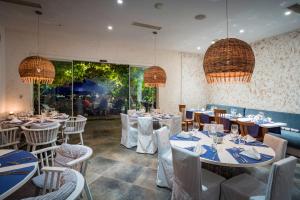 a dining room with tables and chairs and chandeliers at Thracian Cliffs Golf & Beach Resort in Kavarna