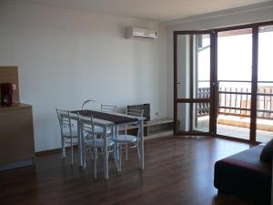 a dining room with a table and chairs and a balcony at Complex Kentavar - Free Fast WiFi in Sveti Vlas