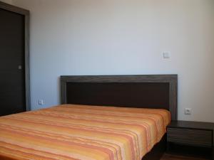 a bedroom with a bed with an orange blanket on it at Complex Kentavar - Free Fast WiFi in Sveti Vlas