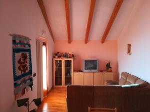 a living room with a couch and a tv at Casa Relax in Pergine Valsugana