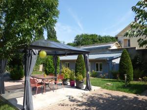 a patio with a table and chairs under a canopy at Gîte de Preuilly in Auxerre