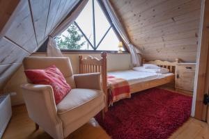 sypialnia z łóżkiem, krzesłem i oknem w obiekcie Gościniec i Herbaciarnia Pod Złotą Łyżwą w mieście Białka Tatrzanska