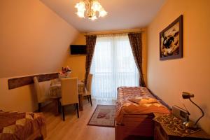a room with two beds and a table and a window at Apartamenty-Wynajem pokoi Zbigniew Tylka in Kościelisko