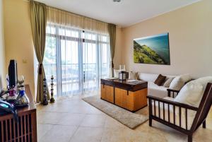 a living room with a couch and a table at Thracian Cliffs Golf & Beach Resort in Kavarna