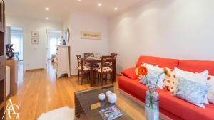 sala de estar con sofá rojo y mesa en Apartamento Plaza de España en Ribadeo