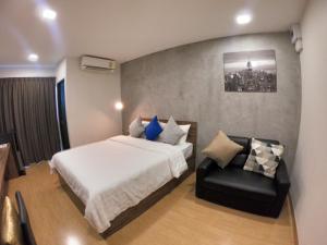 a bedroom with a bed and a chair in it at Tata House in Bangkok