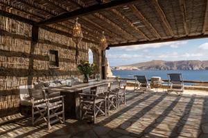 taras ze stołem i krzesłami i widokiem na ocean w obiekcie Summer Mood Villas "Plus" - 6 bedroom villa w mieście Agios Sostis Mykonos
