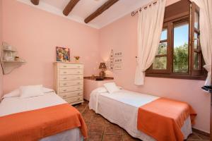 a bedroom with two beds and a window at Hacienda Los Olivos in Ronda