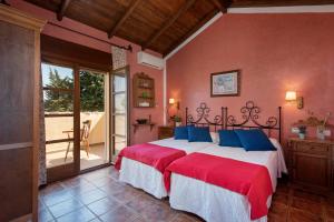a bedroom with a bed with red and blue pillows at Hacienda Los Olivos in Ronda