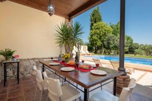 a dining room with a table and chairs and a pool at Hacienda Los Olivos in Ronda