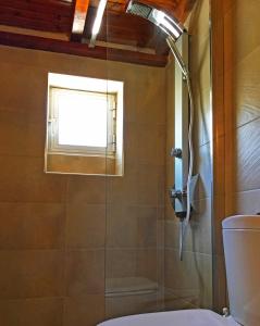 um chuveiro na casa de banho com uma janela em Limani Studio em Lákka
