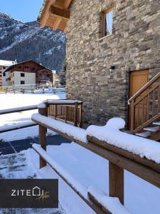 a building with snow on the steps of it at Zitelli Aosta in Cogne +12 photos