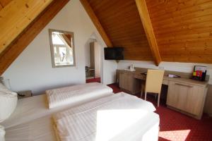a bedroom with a bed and a desk in a attic at Airport Hotel Filder Post in Stuttgart