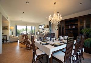 a dining room with a table with chairs and a chandelier at Villa Pleta in Can Picafort