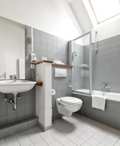 uma casa de banho com um WC, um lavatório e um chuveiro em STAY Boardinghouse Flottbek em Hamburgo