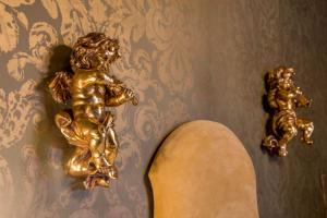 a gold statue of a child on a wall at Boutique Hotel Campo de' Fiori in Rome